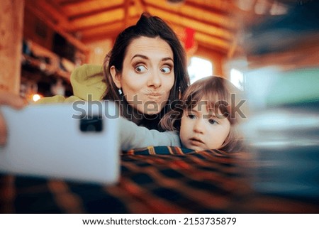 
Mom and Daughter Taking a Selfie Together at the Restaurant. Funny mother and child spending time on the internet

