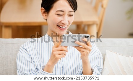 Young woman using a smartphone while sitting on a sofa	