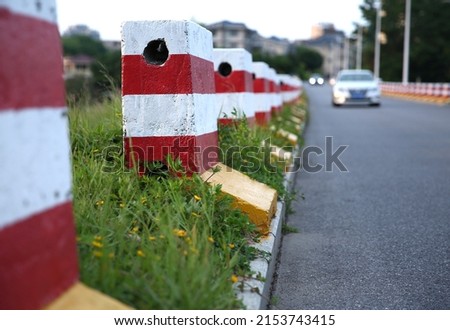 Red and white fences on the background of road works in the city. Construction fences on the road during the day.