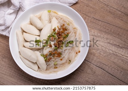 Fish ball noodles in clear broth on wooden floor