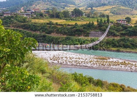 The Punakha Suspension Bridge at the Punakha Dzong. Across the Tsang Chu River to Shengana and Wangkha village. The longest suspension bridge in Bhutan and always decorated with colorful prayer flags.
