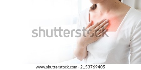 Young woman putting her hand on her chest. Having a pain in chest, Gastroesophageal Reflux Disease  have frequent belching. Healthcare medical concept.  Royalty-Free Stock Photo #2153769405