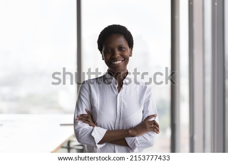 Confident happy African American company owner, business leader woman, female executive, CEO head shot portrait. Millennial black businesswoman looking at camera, smiling with folded arms