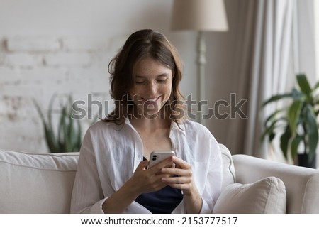 Happy focused on smartphone girl receiving message with good news, enjoying online chat, shopping on Internet, watching video, suffering from digital gadget, social media addiction