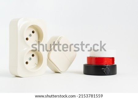 multicolored insulating tape, double socket and two-key light switch on white background. mechanical device for switching lighting circuit, two sockets connected by monolithic case. electronic devices Royalty-Free Stock Photo #2153781559