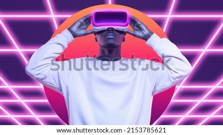 African american man wearing high tech smart vr goggles playing virtual game as super hero in metaverse Royalty-Free Stock Photo #2153785621