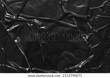 black crumpled and creased plastic poster texture background Royalty-Free Stock Photo #2153790075