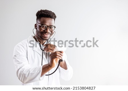 Portrait Of Mature Male Doctor Wearing White Coat Standing In Hospital Corridor. Male Doctor With Stethoscope Wearing White Coat Standing In Modern Hospital Building