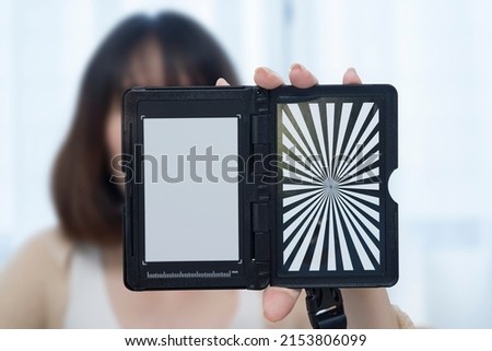 Custom white balance in the hands of a girl. The model holds a custom white balance in its hands for white balance transfer during further.