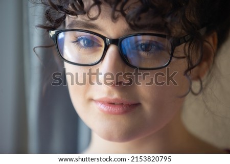 Portrait of beautiful Ukrainian woman in nerd glasses. Cute young female with curly hair 
