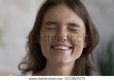 Cheerful excited freckled teen girl laughing with closed eyes. Happy overjoyed young woman with spotted facial skin, fresh natural complexion, white teeth close up face portrait. Beauty care concept Royalty-Free Stock Photo #2153829271