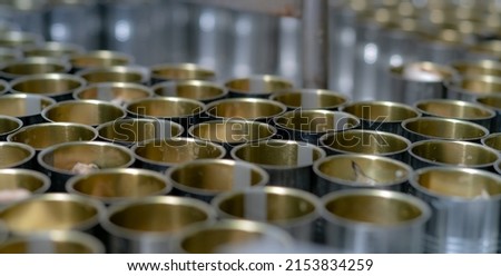Canned fish factory. Food industry.  Many can of sardines on a conveyor belt. Sardines in red tomato sauce in tinned cans at food factory. Food processing production line. Food manufacturing industry. Royalty-Free Stock Photo #2153834259