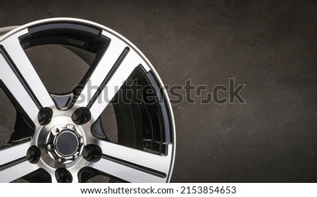 new black alloy wheels on a dark textured black background. wheel for car spare parts auto repair tire shop, copy space panorama empty Royalty-Free Stock Photo #2153854653