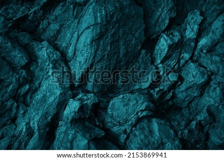 Green blue rock texture. Toned rough mountain surface texture. Crumbled. Close-up. Dark teal rocky background with space for design. Fantasy.                                 