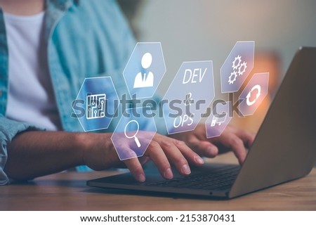 DevOps concept, software development, IT operations, agile programming, Concept with dev ops icon on computer screen and project manager, coder or sysadmin typing on keyboard, high software quality Royalty-Free Stock Photo #2153870431
