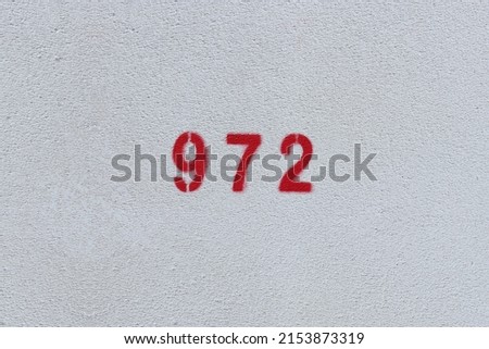 RED Number 972 on the white wall. Spray paint.
