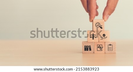 Audit business concept. Examination and evaluation of the financial statements of an organization; income statement, balance sheet
,cash flow statement.  Holding wooden cubes with audit icon. Royalty-Free Stock Photo #2153883923