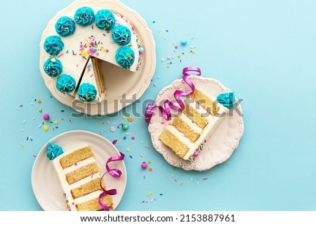 Birthday party background with birthday cake and birthday cake slices, overhead view Royalty-Free Stock Photo #2153887961
