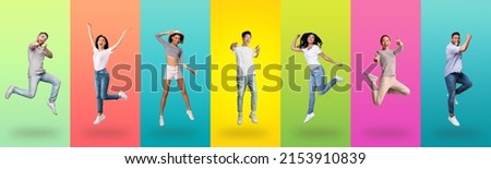 Carefree millennial diverse people jumping up, celebrating victory and pointing finger at you camera, posing together on colorful gradient studio background wall, full length shot, panorama banner Royalty-Free Stock Photo #2153910839