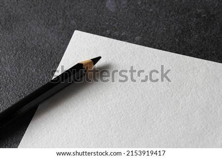 Paper mockup. Watercolor A4 paper with black pencil on dark background. Side view. Can be used as a template for drawings or logo. Royalty-Free Stock Photo #2153919417