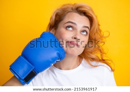 Close up portrait of funny woman with boxing gloves with punching face isolated on yellow background Woman in boxing gloves.