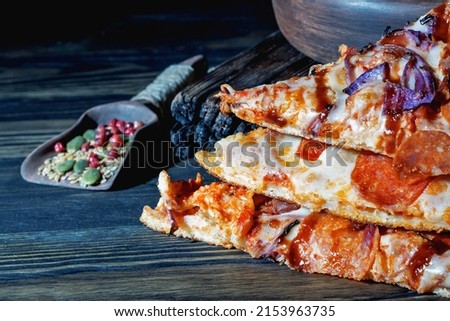 Fresh slices of pizza on a wooden background. Close-up.

