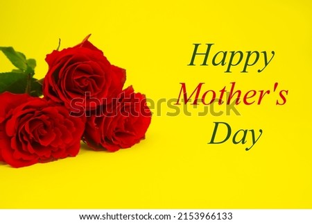 Red roses for mom on a yellow background, text HAPPY MOTHER'S DAY, in green and red. The concept of a gift, congratulation, gratitude, postcard, surprise. High quality photo