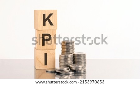 kpi - text on wooden cubes on white background with coins