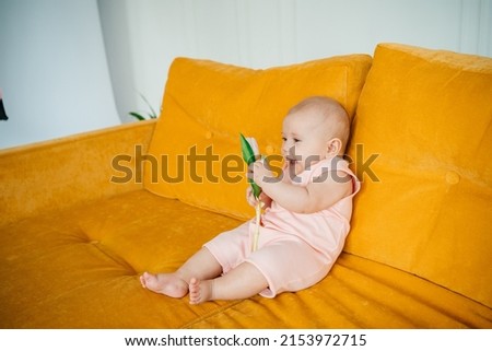 child on a yellow sofa with flowers at home. High quality photo