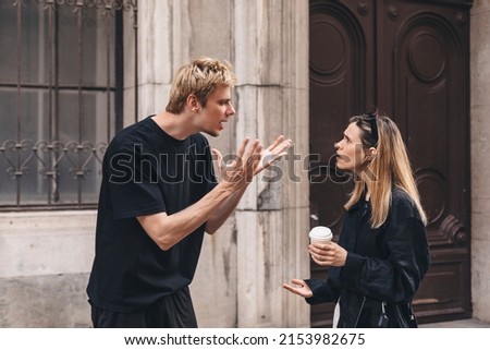 Young arguing sad couple two friends family man woman in casual clothes screaming scolding together walking outdoor near door of home. Man yelling at woman. Couple arguing, having relationship problem Royalty-Free Stock Photo #2153982675