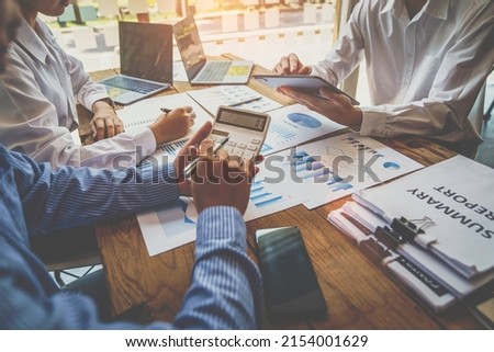 Business team finance or bookkeeper working with a calculator to calculate business data summary report, accountancy document and laptop computer at the office, business meeting concept Royalty-Free Stock Photo #2154001629