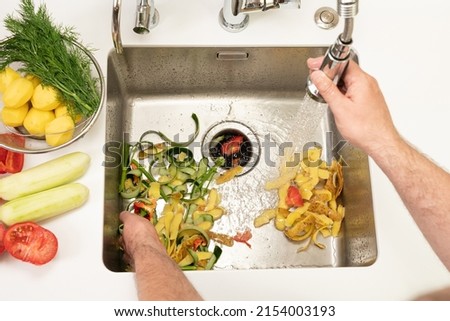 Food waste after peeling vegetables is destroyed using the Disposer Royalty-Free Stock Photo #2154003193