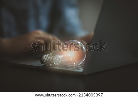 light bulb on keyboard laptop, New ideas, innovation, inspiration and creativity concept,African american businessman with illuminated light bulb, 