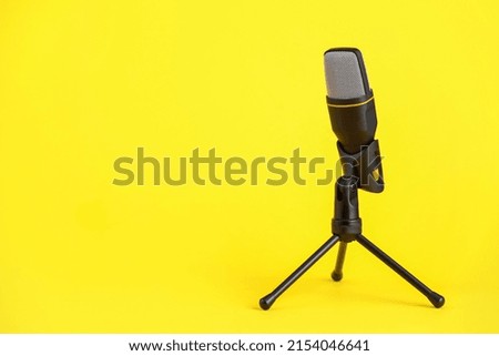 Stand with microphone on yellow background