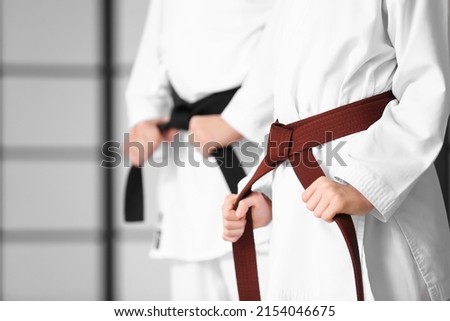 Boy and karate instructor in dojo, closeup Royalty-Free Stock Photo #2154046675