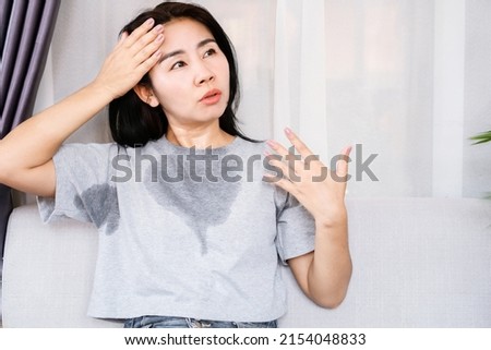 Asian woman sweating because of hot weather, menopause symptom concept  Royalty-Free Stock Photo #2154048833