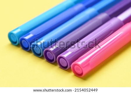 Felt tip pens on yellow background, closeup