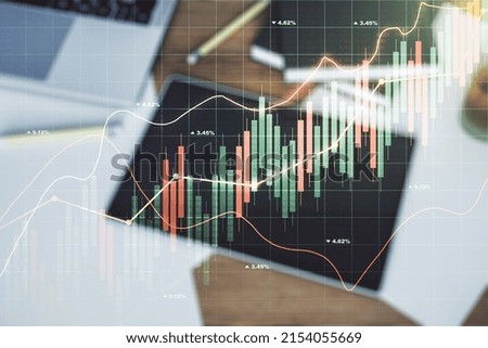 Double exposure of abstract creative financial chart and digital tablet on background, top view, research and strategy concept