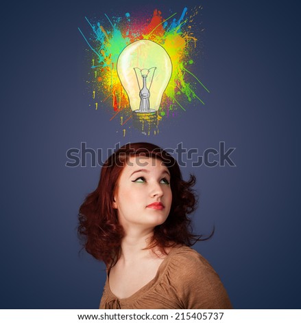 Pretty young woman gesturing with lightbulb and paint splashes above her head