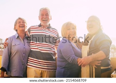 Portrait of happy and cheerful mature senior people enjoying friendship outdoor. Retired group of friends standing and posing for a picture having fun ald laughing a lot together