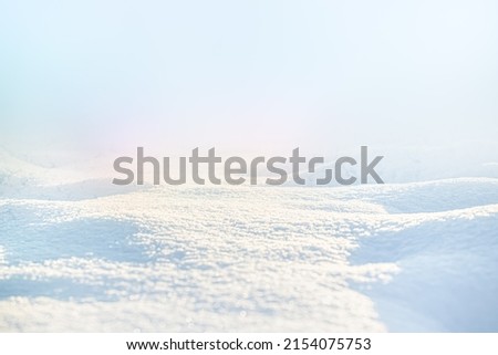 WHITE SNOW IN SUN LIGHT ON LIGHT BLUE FROSTY SKY, BRIGHT WINTER BACKDROP BACKGROUND WITH EMPTY SNOWY FIELD SPACE FOR MONTAGE OR DISPLAY, COLD NATURE LANDSCAPE Royalty-Free Stock Photo #2154075753