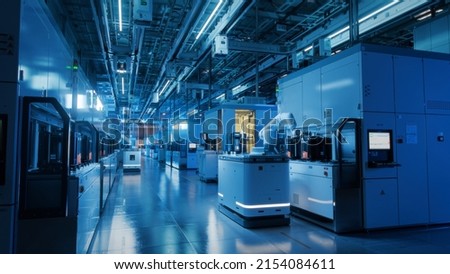 Wide Shot Inside Advanced Semiconductor Production Fab Cleanroom. Automated Robots are Transporting Wafers between Machines. Royalty-Free Stock Photo #2154084611