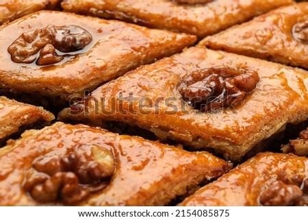 Delicious honey baklava with walnuts as background, closeup