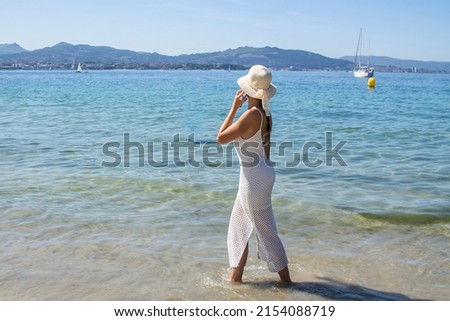 happy young woman walking on the beach and talking on mobile phone
