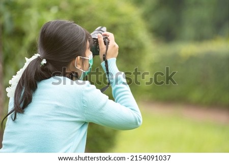 Woman is a professional photographer with  camera, outdoor and sunlight, Portrait, copy space.Beautiful woman taking picture outdoors