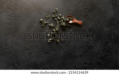 dried mint on a dark textured background. mint leaves on a spoon