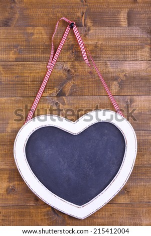 Heart shaped chalkboard on wooden background