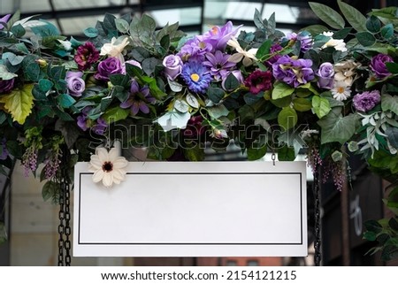 Blank wedding board sign mockup scene. Empty white welcome board with flowers. Floral garland on arc, birthday party decoration.