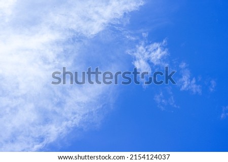 Blue sky background with flowing clouds.