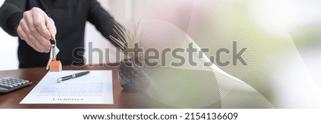 Real estate agent showing house keys after contract signing; panoramic banner